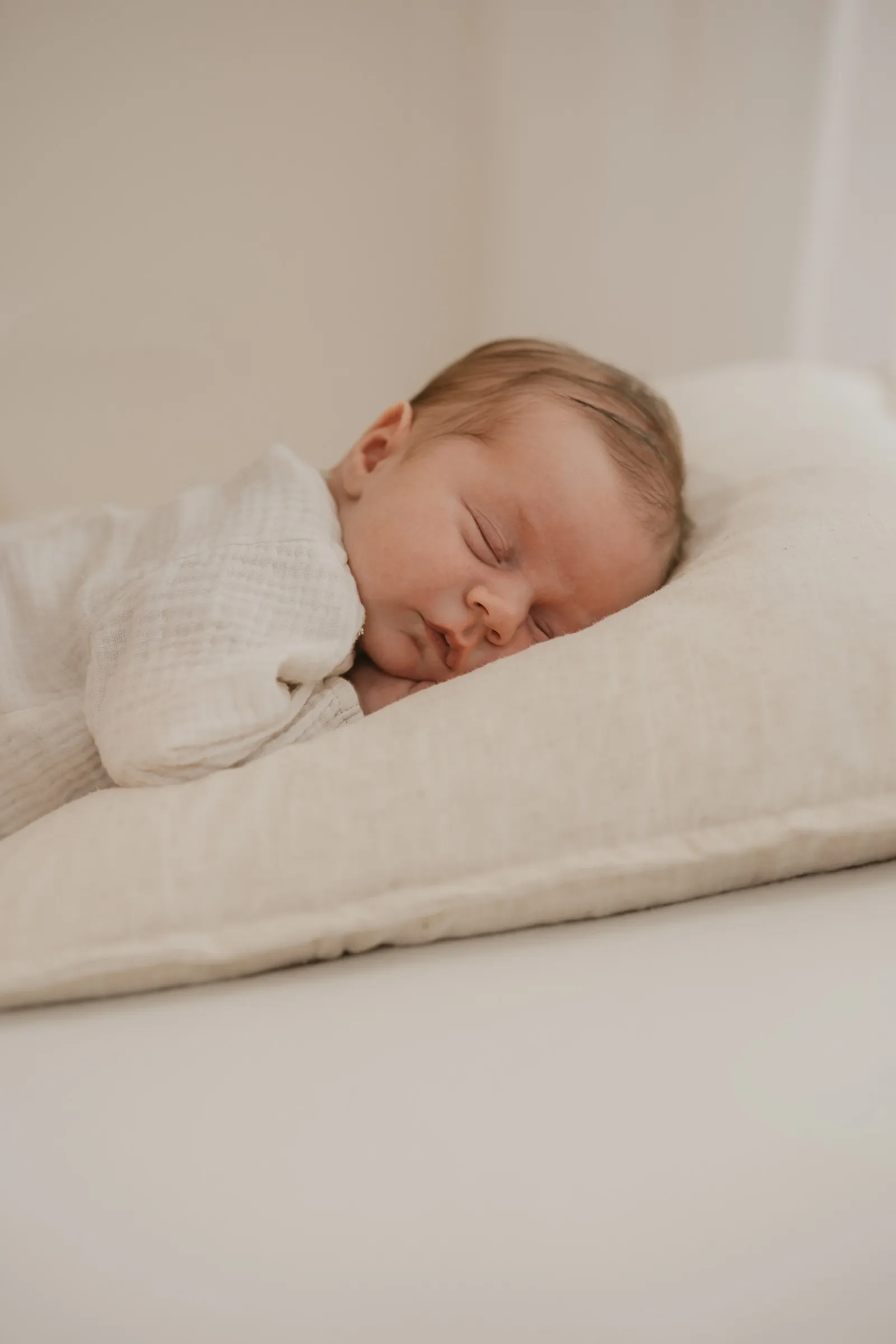 Newborn Fotoshooting: Schlafendes Neugeborenes auf Kissen